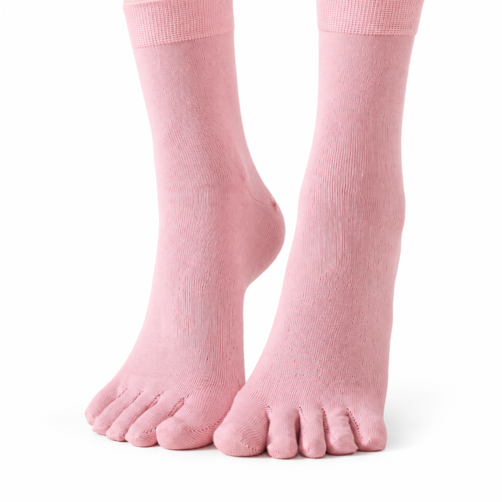 Pink five-toe socks worn on feet against a white background.